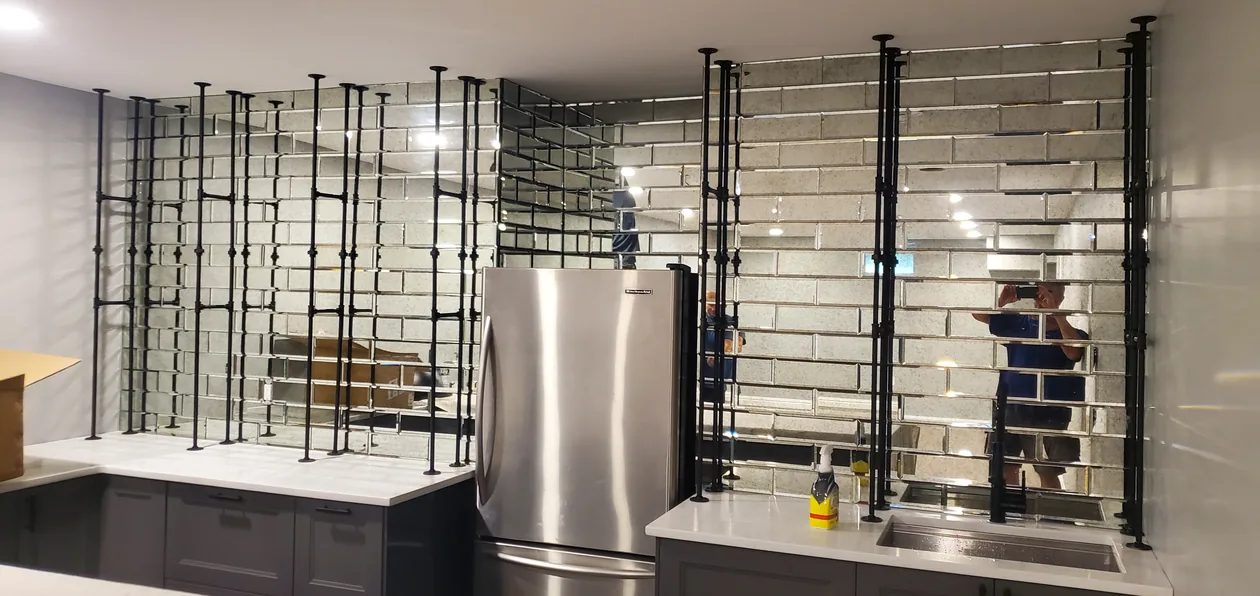 Kitchen cabinets and tall open storage beside a refrigerator.