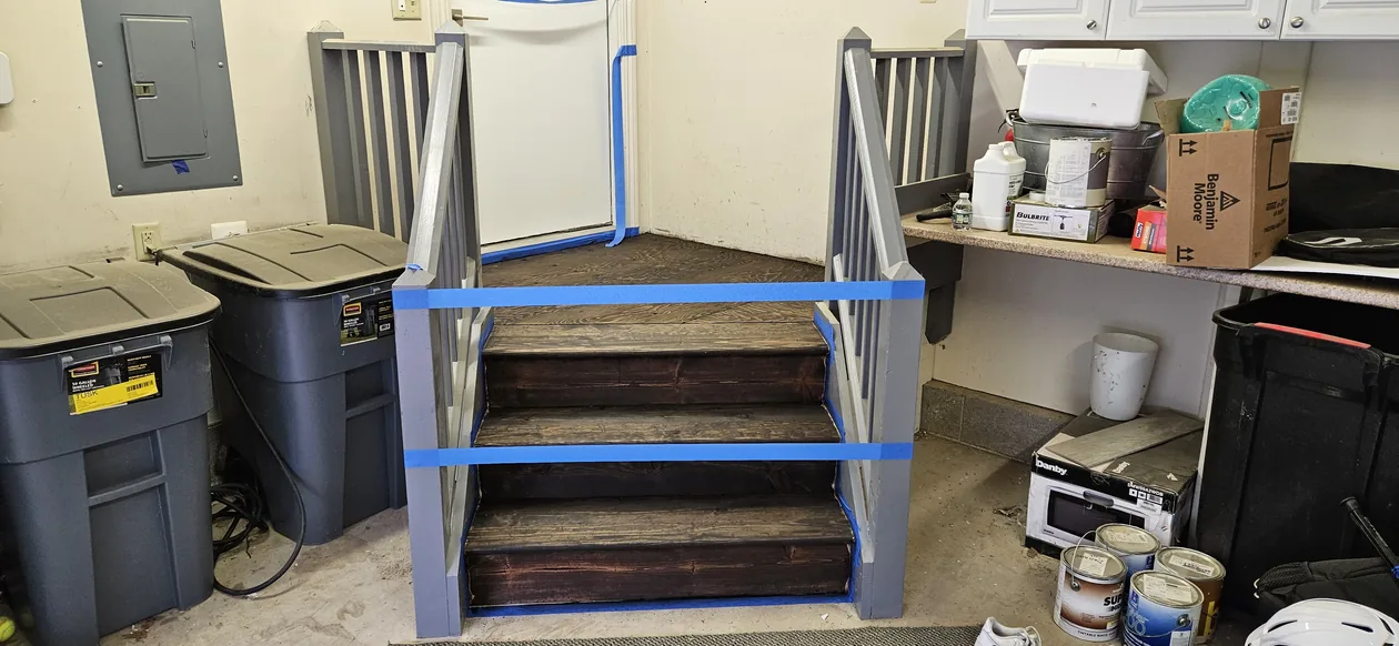 Wooden steps and landing arranged in a garage work area.