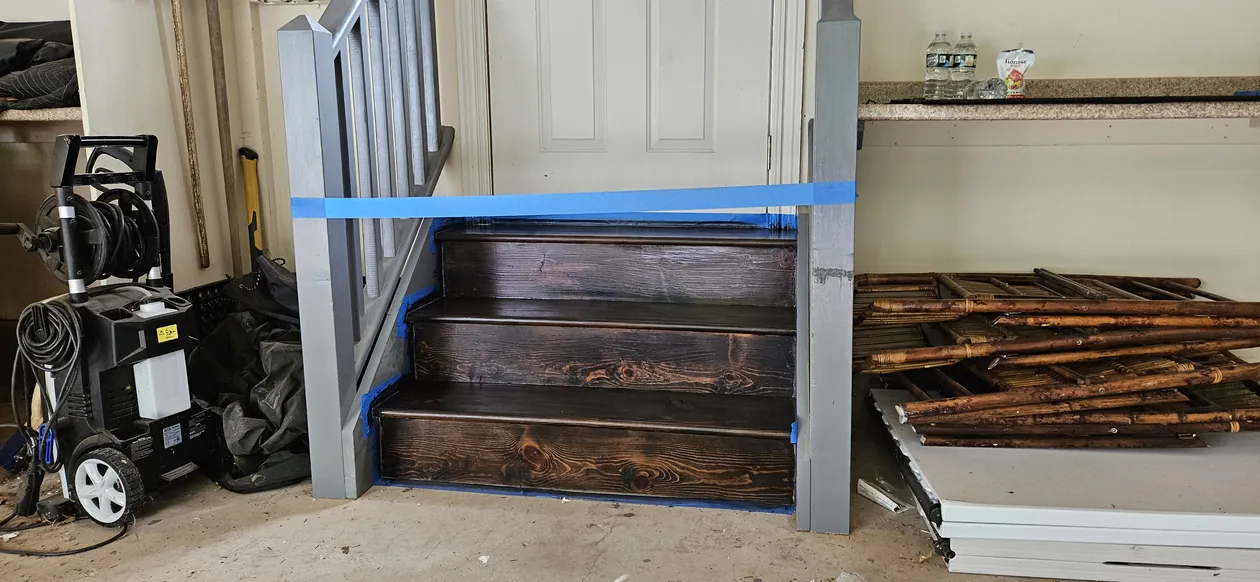 Wooden steps and landing arranged in a garage work area from another angle.