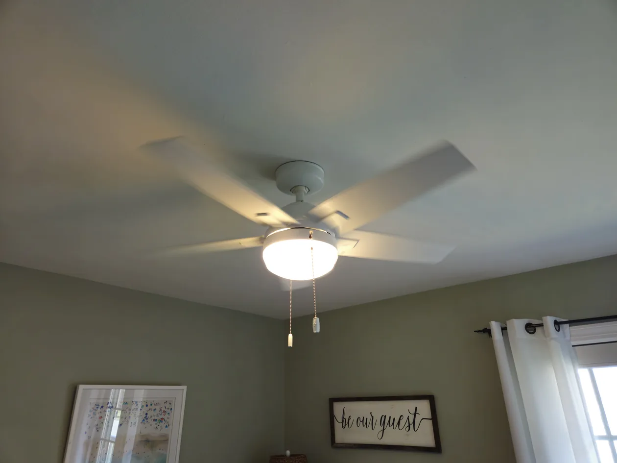 Ceiling fan with a light in a bedroom.