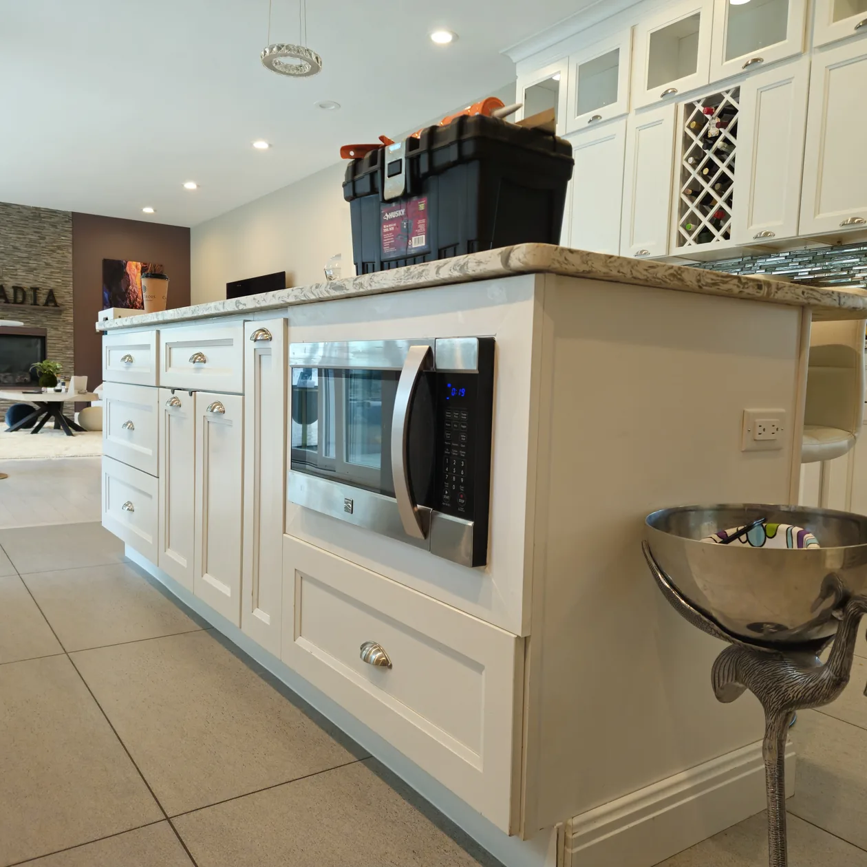 Light kitchen cabinets and countertop beside a built-in oven and microwave.