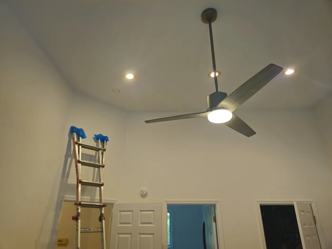 Ceiling fan above a doorway with an access ladder nearby.