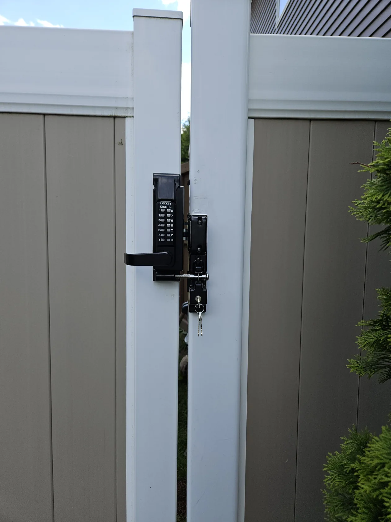 Keypad and latch attached to an outdoor gate.